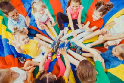 Children playing with parachute at gymnastics day camp